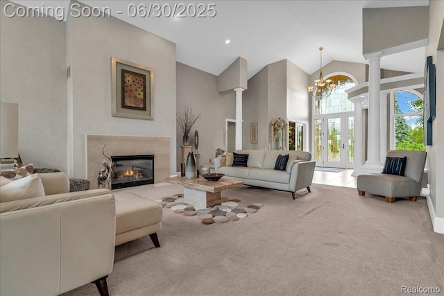 550 Kings Fairway Ct, Grand Blanc, MI 48439 - carpeted living room featuring high vaulted ceiling, a chandelier, a premium fireplace, and decorative columns
