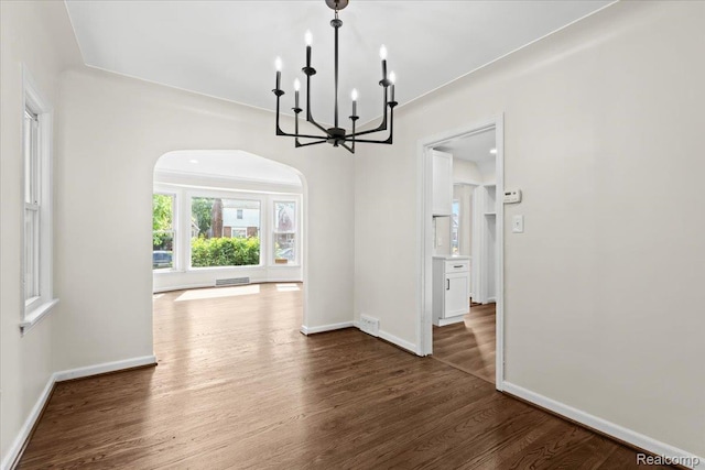18639 Kentucky St, Detroit, MI 48221 - unfurnished dining area with arched walkways, a chandelier, and dark wood-type flooring