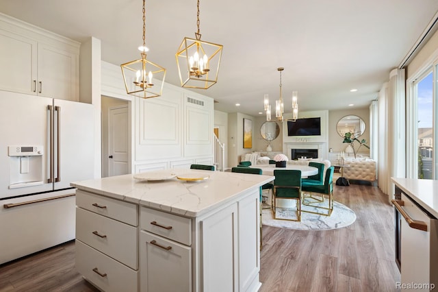 1957 Emerald Ln, Wixom, MI 48393 - kitchen with white appliances, a chandelier, a center island, light wood-type flooring, and white cabinetry
