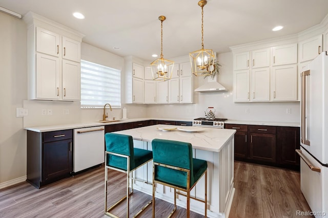 1957 Emerald Ln, Wixom, MI 48393 - kitchen featuring high end appliances, a chandelier, wood finished floors, white cabinets, and recessed lighting