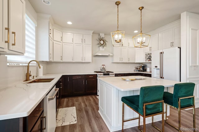 1957 Emerald Ln, Wixom, MI 48393 - kitchen featuring high end appliances, a chandelier, dark brown cabinets, wood finished floors, and white cabinets