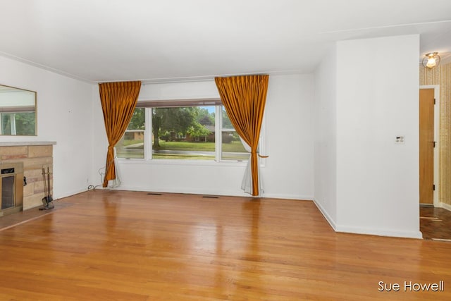 1547 Edith Ave NE, Grand Rapids, MI 49505 - unfurnished living room featuring a stone fireplace and light wood-type flooring