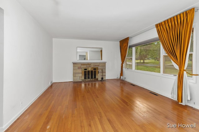 1547 Edith Ave NE, Grand Rapids, MI 49505 - unfurnished living room with wood finished floors and a stone fireplace