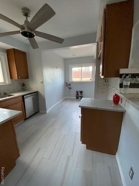 14402 Southfield Rd, Detroit, MI 48223 - kitchen with stainless steel dishwasher, brown cabinets, and decorative backsplash