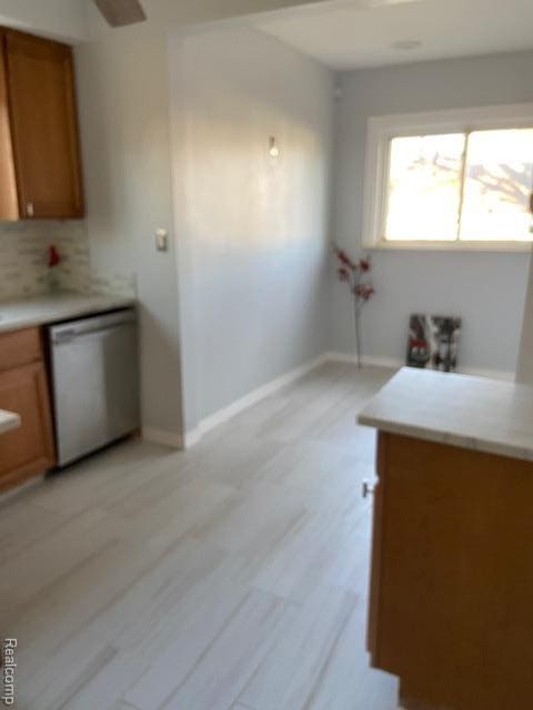 14402 Southfield Rd, Detroit, MI 48223 - kitchen featuring dishwasher, brown cabinetry, tasteful backsplash, light countertops, and light wood-style floors