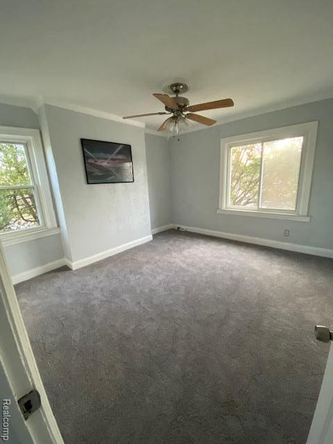 14402 Southfield Rd, Detroit, MI 48223 - spare room featuring plenty of natural light, dark colored carpet, and a ceiling fan