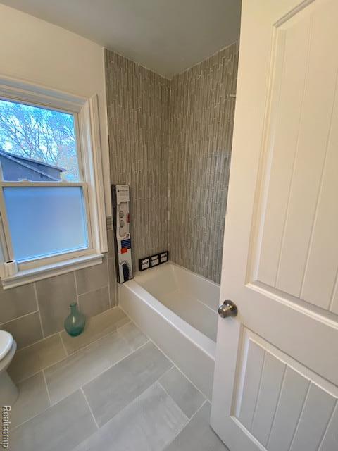14402 Southfield Rd, Detroit, MI 48223 - full bathroom with tile patterned flooring, tub / shower combination, and tile walls