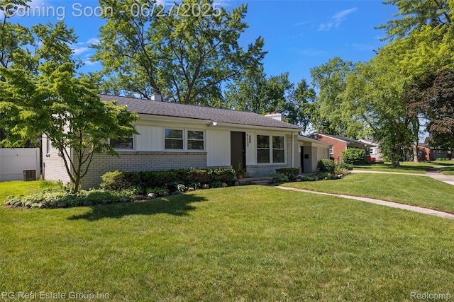 4550 Justine St, Shelby Twp, MI 48317 - view of front of property with brick siding, a front lawn, a chimney, and a shingled roof