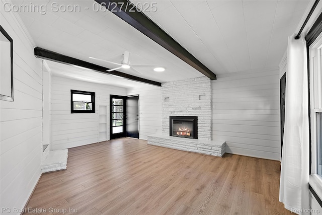 4550 Justine St, Shelby Twp, MI 48317 - unfurnished living room featuring beamed ceiling, wood finished floors, wooden walls, ceiling fan, and a fireplace