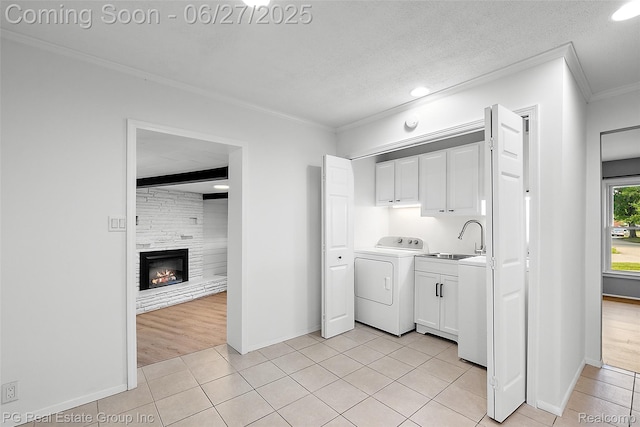 4550 Justine St, Shelby Twp, MI 48317 - laundry area featuring cabinet space, washer / clothes dryer, ornamental molding, light tile patterned floors, and a fireplace