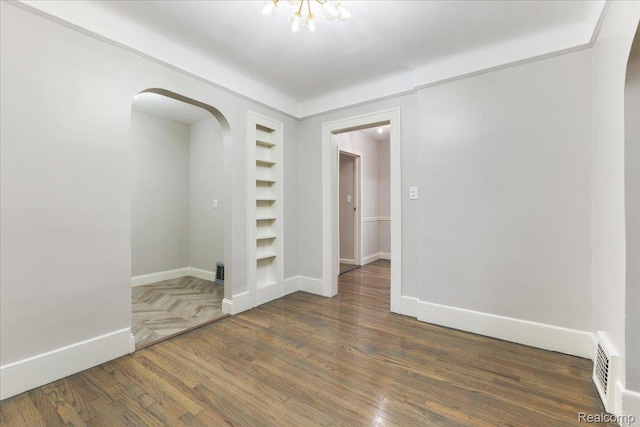 192 W Hopkins Ave, West Bloomfield, MI 48340 - empty room with arched walkways, wood finished floors, and built in features
