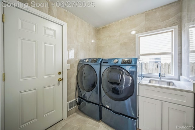 1730 E Woodruff Ave, Hazel Park, MI 48030 - laundry room with washing machine and clothes dryer, tile walls, and cabinet space