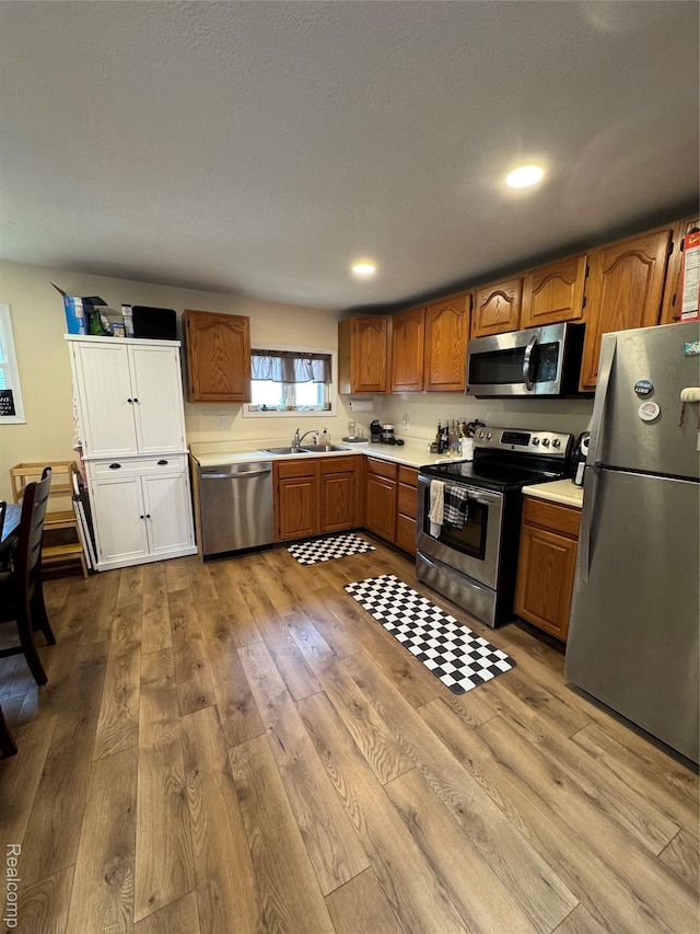 338 Green, Perry, MI 48872 - kitchen featuring appliances with stainless steel finishes, light wood-style flooring, light countertops, brown cabinetry, and recessed lighting