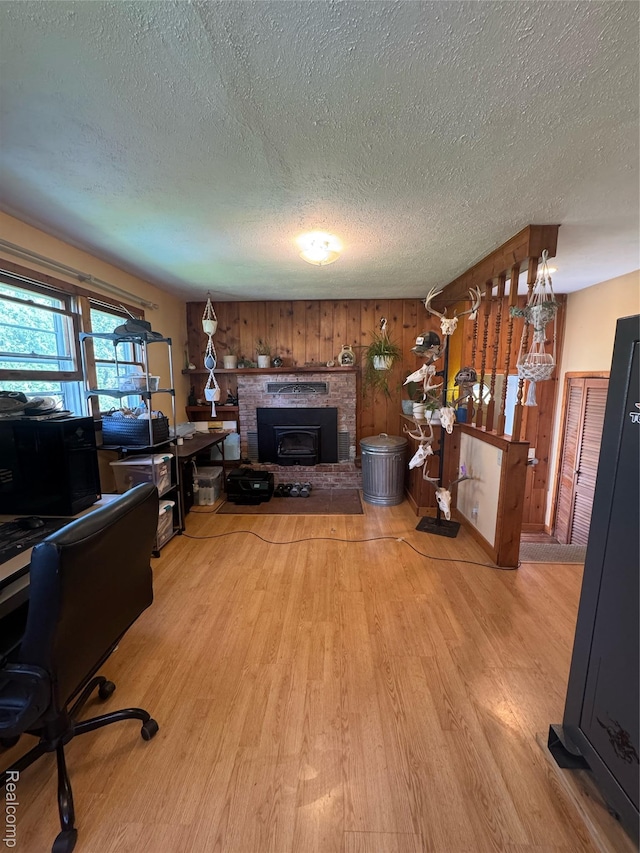 338 Green, Perry, MI 48872 - living room featuring a textured ceiling, wood finished floors, a fireplace, a desk, and wooden walls