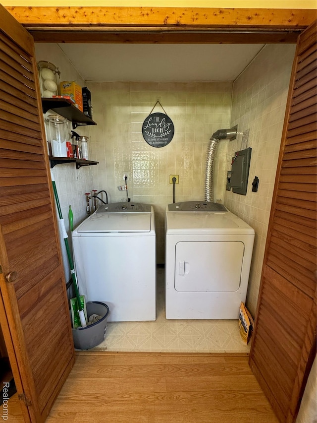 338 Green, Perry, MI 48872 - laundry area featuring washer and dryer, electric panel, and light wood-style flooring