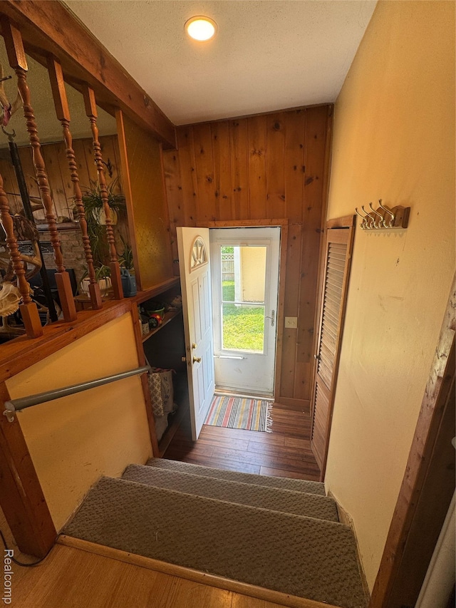 338 Green, Perry, MI 48872 - stairway featuring wood walls, wood finished floors, and a textured ceiling