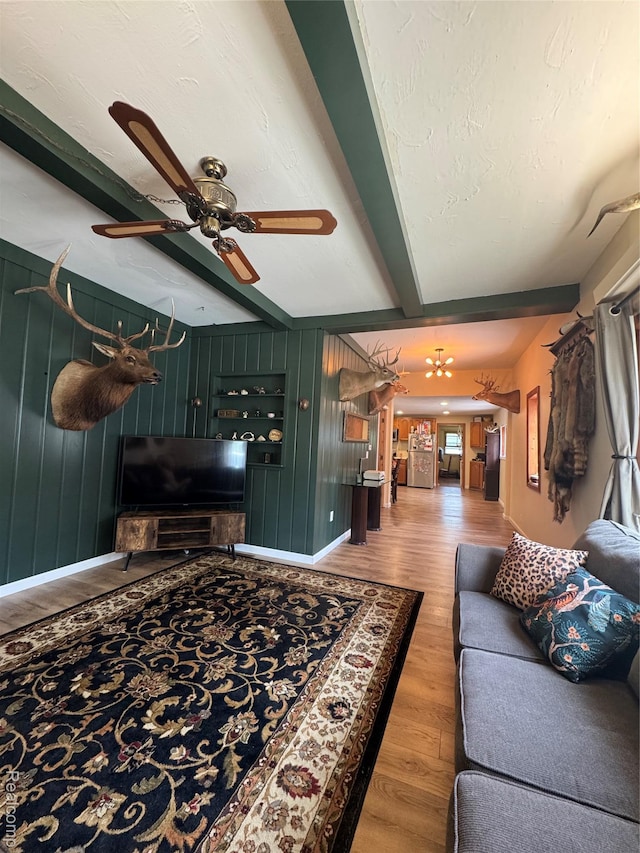 338 Green, Perry, MI 48872 - living area with light wood finished floors, beamed ceiling, ceiling fan, and wood walls