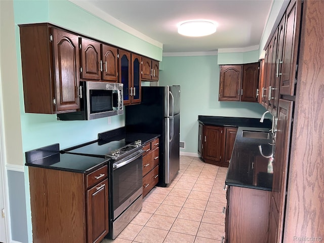 6197 Sober Rd, Fowlerville, MI 48836 - kitchen featuring appliances with stainless steel finishes, dark countertops, light tile patterned floors, ornamental molding, and dark brown cabinets