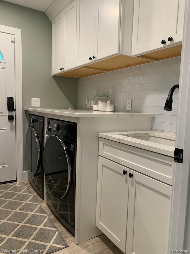 1485 Paramount St, Novi, MI 48377 - washroom featuring separate washer and dryer, cabinet space, and light wood finished floors