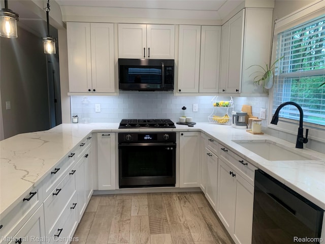 1485 Paramount St, Novi, MI 48377 - kitchen with black appliances, white cabinetry, backsplash, and light stone countertops