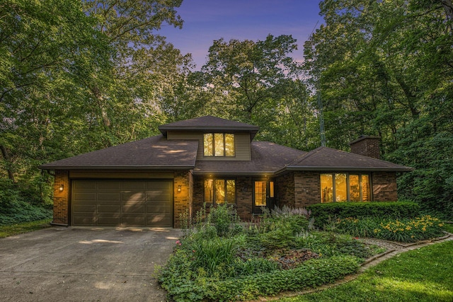 1769 Maple Ln, Benton Harbor, MI 49022 - prairie-style house with concrete driveway, a garage, brick siding, a chimney, and roof with shingles