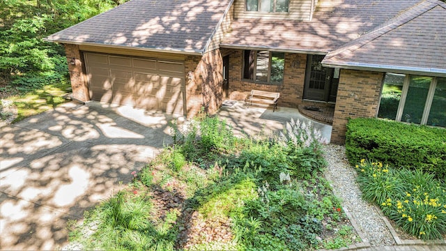 1769 Maple Ln, Benton Harbor, MI 49022 - view of front facade with brick siding, roof with shingles, a garage, and concrete driveway
