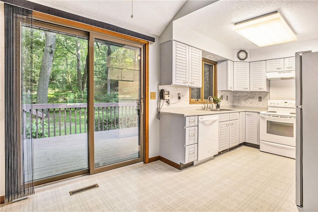 1769 Maple Ln, Benton Harbor, MI 49022 - kitchen featuring white appliances, under cabinet range hood, light countertops, decorative backsplash, and a textured ceiling