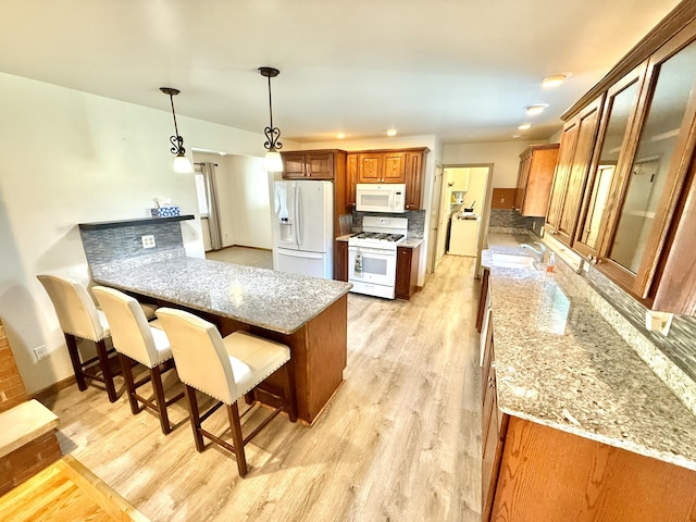 10844 Judd Rd, Willis, MI 48191 - kitchen with white appliances, brown cabinetry, a breakfast bar area, a peninsula, and light wood-style floors