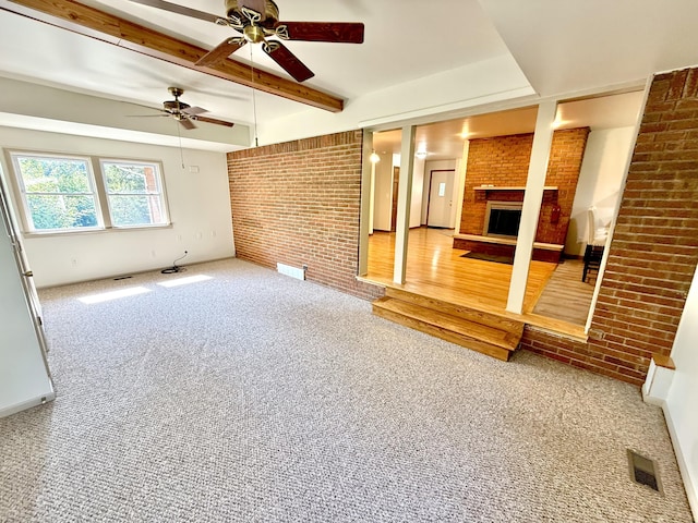 10844 Judd Rd, Willis, MI 48191 - unfurnished living room featuring brick wall, a fireplace, ceiling fan, carpet, and beam ceiling