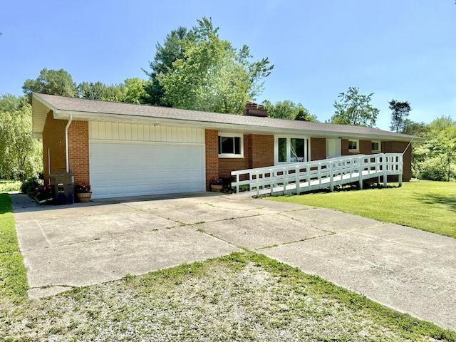 10844 Judd Rd, Willis, MI 48191 - single story home with brick siding, a garage, concrete driveway, and a front lawn