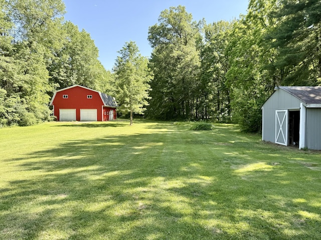 10844 Judd Rd, Willis, MI 48191 - view of grassy yard featuring a garage, an outbuilding, and a view of trees
