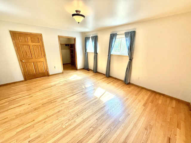 10844 Judd Rd, Willis, MI 48191 - unfurnished bedroom with light wood finished floors, a spacious closet, and a closet