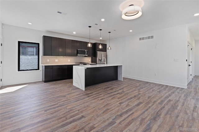 5216 Avery St, Detroit, MI 48208 - kitchen with stainless steel appliances, light countertops, an island with sink, open floor plan, and wood finished floors