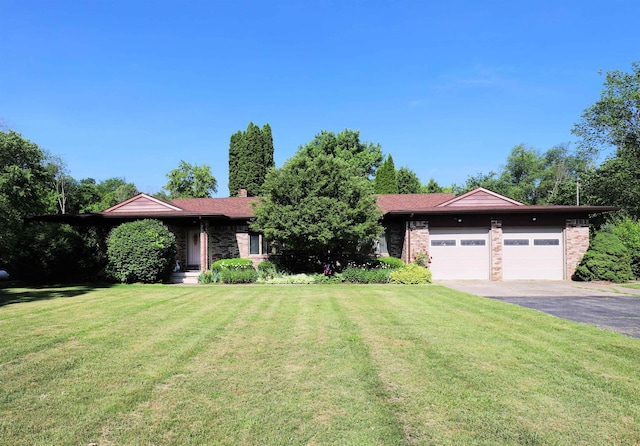 8141 N Elms Rd, Flushing, MI 48433 - ranch-style home with asphalt driveway, a front lawn, a garage, and brick siding