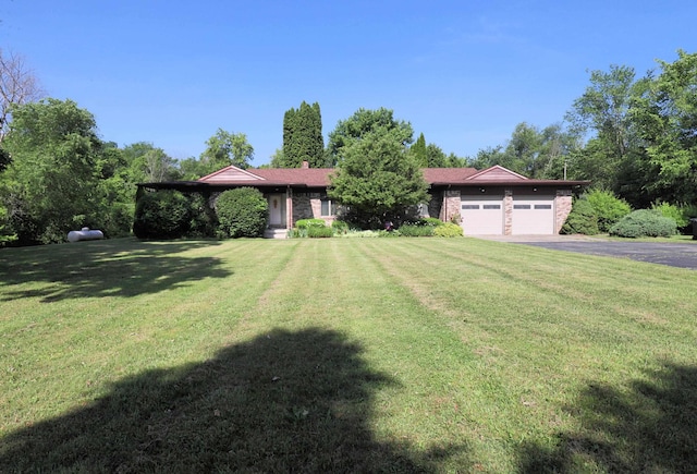 8141 N Elms Rd, Flushing, MI 48433 - view of front of home with an attached garage, asphalt driveway, and a front lawn
