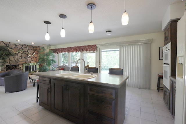 8141 N Elms Rd, Flushing, MI 48433 - kitchen with light tile patterned floors, decorative light fixtures, and a stone fireplace