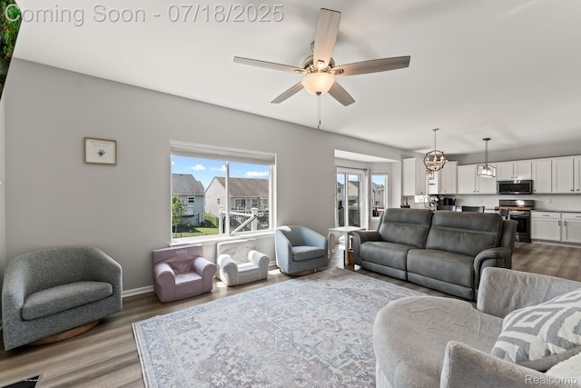 4074 Peach Tree Ln, Howell, MI 48843 - living room with dark wood finished floors, ceiling fan, and a chandelier
