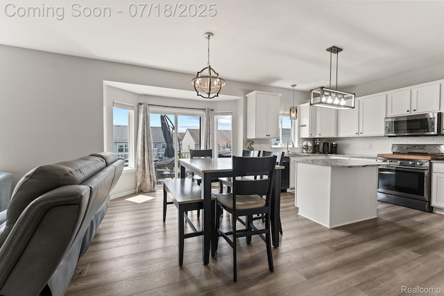 4074 Peach Tree Ln, Howell, MI 48843 - dining space with healthy amount of natural light, dark wood-style flooring, and a chandelier