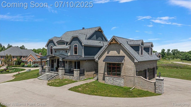 6295 Canter Creek Trl, Grand Blanc, MI 48439 - view of front of house featuring an attached garage, stone siding, driveway, covered porch, and a front yard