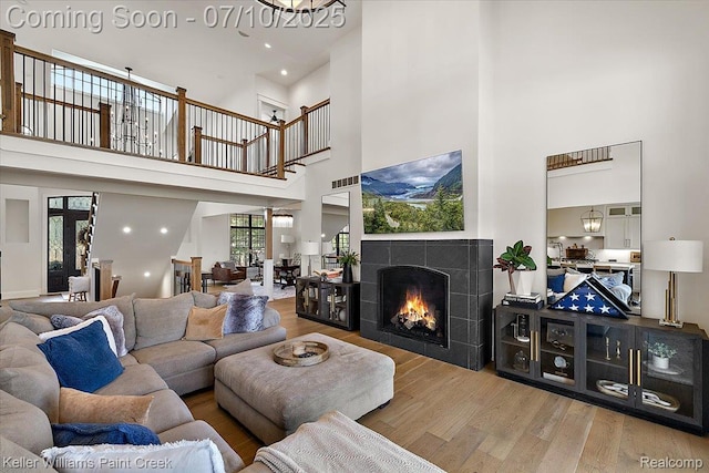 6295 Canter Creek Trl, Grand Blanc, MI 48439 - living area with a high ceiling, wood finished floors, and a fireplace