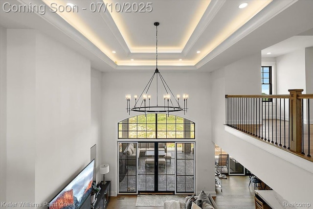 6295 Canter Creek Trl, Grand Blanc, MI 48439 - stairs featuring a high ceiling, a chandelier, healthy amount of natural light, a raised ceiling, and wood finished floors