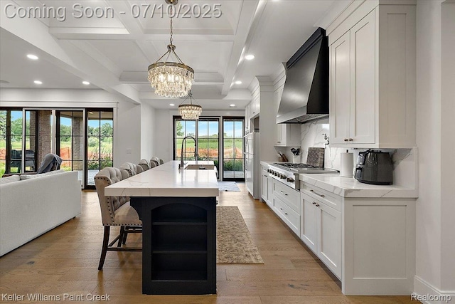 6295 Canter Creek Trl, Grand Blanc, MI 48439 - kitchen featuring premium range hood, stainless steel gas stovetop, open floor plan, recessed lighting, and freestanding refrigerator
