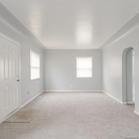 440 Jewell St, Southfield, MI 48220 - empty room featuring arched walkways, light colored carpet, and healthy amount of natural light