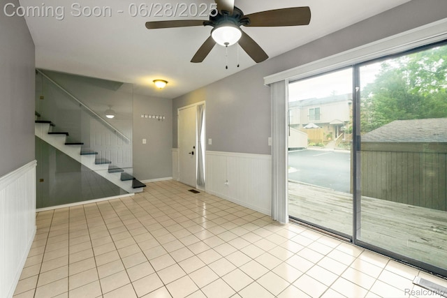 1481 Oakbrook E, Rochester, MI 48307 - unfurnished room featuring a ceiling fan, a wainscoted wall, stairway, and light tile patterned floors