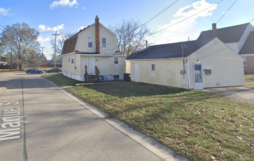 3037 24th St, Port Huron, MI 48060 - view of property exterior featuring entry steps, a gambrel roof, a chimney, a lawn, and a wall mounted air conditioner