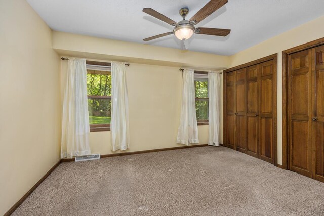 2360 Montclair Ave NW, Walker, MI 49544 - unfurnished bedroom with carpet, multiple windows, two closets, and ceiling fan