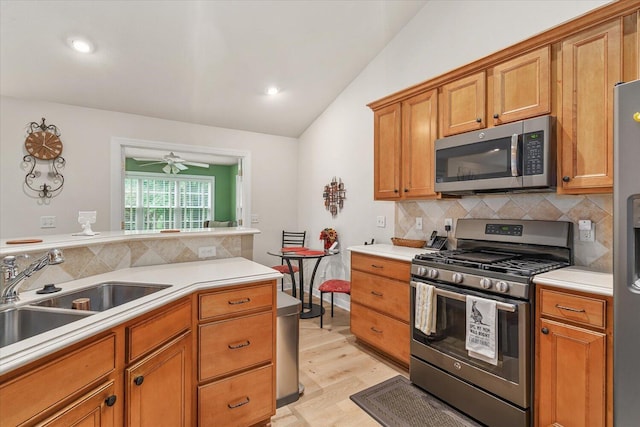 7520 Haflinger Cir, Kalamazoo, MI 49009 - kitchen featuring stainless steel appliances, vaulted ceiling, tasteful backsplash, light countertops, and brown cabinetry