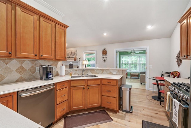 7520 Haflinger Cir, Kalamazoo, MI 49009 - kitchen featuring stainless steel appliances, a peninsula, light wood-type flooring, light countertops, and decorative backsplash