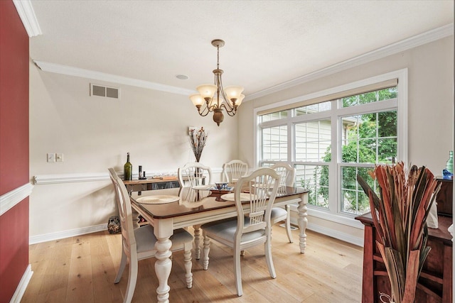 7520 Haflinger Cir, Kalamazoo, MI 49009 - dining area featuring crown molding, a chandelier, healthy amount of natural light, and light wood finished floors