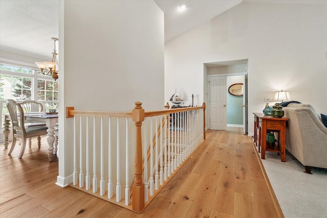 7520 Haflinger Cir, Kalamazoo, MI 49009 - corridor with wood-type flooring, a chandelier, an upstairs landing, ornamental molding, and lofted ceiling